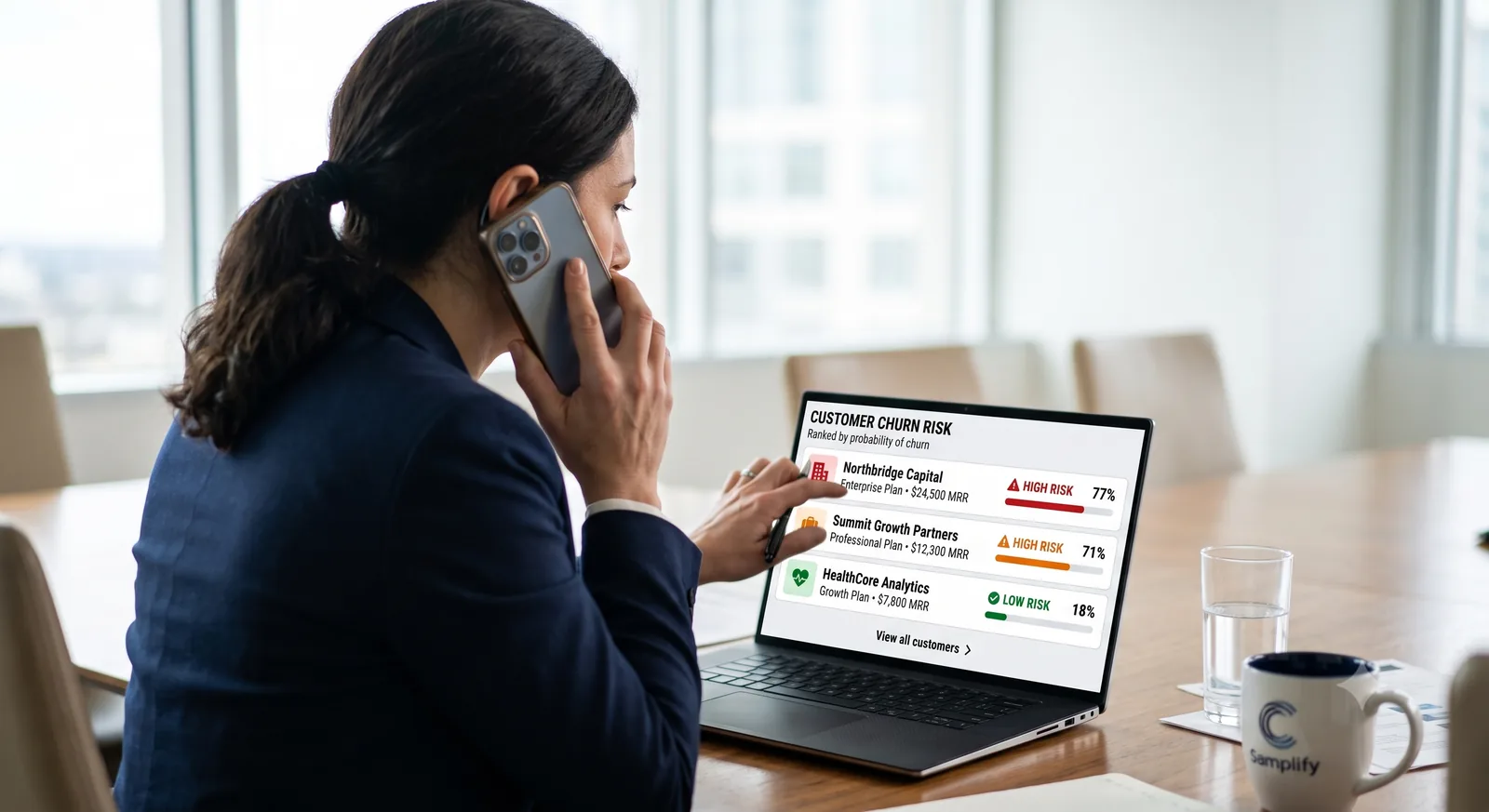 Finance leader reviewing a ranked customer churn risk list on a laptop while on a call